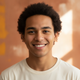 Headshot of a smiling young adult, conveying satisfaction and trustworthiness.